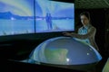 Woman using interactive model of Earth at museum