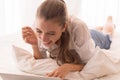 Woman using internet on laptop while lying on bed at home,Happy and smiling,Enjoying time Royalty Free Stock Photo