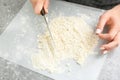 Woman using knife to make dough, closeup