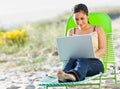 Woman using laptop at beach Royalty Free Stock Photo