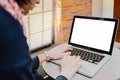 Woman using laptop with blank screen on table