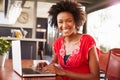 Woman using a laptop at a coffee shop, portrait Royalty Free Stock Photo