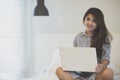 Woman using a laptop computer while lying on her bed Royalty Free Stock Photo