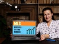 Woman using laptop computer with MLS MULTIPLE LISTING SERVICE icon on screen background, success in business concept