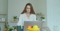 Woman using laptop computer. Portrait of business woman watching news at laptop screen and drinking coffee at home Royalty Free Stock Photo