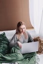 Young woman working on computer in bed. Relaxing at home. Royalty Free Stock Photo