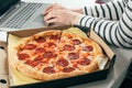Woman using laptop and eating pizza. Concept of food delivery, quarantine, takeout food. home office