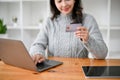 A woman using laptop, holding a credit card, register credit card on the shopping website Royalty Free Stock Photo