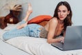 Woman using laptop at home in bedroom. Working from home.