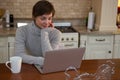 Woman using laptop in kitchen Royalty Free Stock Photo