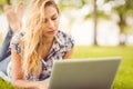 Woman using laptop while lying on front in grass Royalty Free Stock Photo