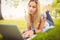 Woman using laptop while lying on grass Royalty Free Stock Photo