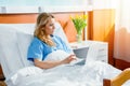 Woman using laptop while lying in hospital bed Royalty Free Stock Photo