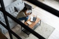 Woman using laptop and mobile phone on sofa. Royalty Free Stock Photo