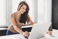 Woman using laptop in office. Beautiful girl working at home. Royalty Free Stock Photo