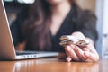 A woman using laptop while playing fidget spinner on wooden table