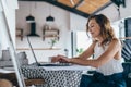 Woman using laptop while sitting at home. Young woman sitting in kitchen and working on laptop. Royalty Free Stock Photo