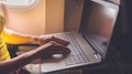 Woman using laptop while is sitting in plane near window. Royalty Free Stock Photo