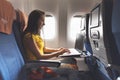 Woman using laptop while is sitting in plane near window. Royalty Free Stock Photo