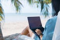 Woman using laptop and smartphone to work study in vacation cady at beach background Royalty Free Stock Photo
