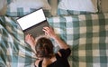 Woman using laptop or tablet in bed white empty screen for copy space Royalty Free Stock Photo