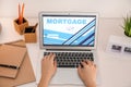 Woman using laptop to pay mortgage loan online at home