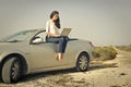 Woman using laptop on top of the car Royalty Free Stock Photo