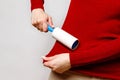 Woman using a lint remover/sticky roller to clean fabrics Royalty Free Stock Photo