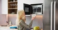 Woman Using Microwave Oven For Heating Food Royalty Free Stock Photo