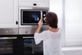 Woman Using Microwave Oven Royalty Free Stock Photo