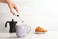 Woman using milk frother in cup on table Royalty Free Stock Photo