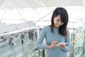 Woman using mobile phone at airport Royalty Free Stock Photo