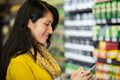 Woman using mobile phone in grocery section Royalty Free Stock Photo