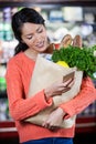 Woman using mobile phone while holding groceries Royalty Free Stock Photo