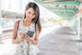 Woman using mobile phone in light rail station Royalty Free Stock Photo