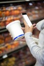 Woman using mobile phone while shopping for grocery Royalty Free Stock Photo