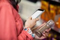 Woman using mobile phone while shopping for grocery Royalty Free Stock Photo