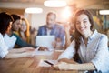 Woman using mobile phone while team working in background Royalty Free Stock Photo