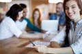 Woman using mobile phone while team working in background Royalty Free Stock Photo