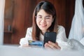 Woman using mobile smart phone and credit card for online shopping while making order on bed in morning at home. technology, Royalty Free Stock Photo