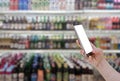 Woman using mobile smart phone in supermarket Royalty Free Stock Photo