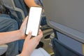 Woman Using mockup Mobile Phone While Sitting In Airplane. Woman using smartphone in airplane during flight. Mockup image of a Royalty Free Stock Photo