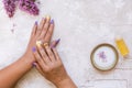 Beautiful woman putting lilac cream on her hand