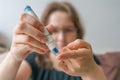 Woman is using needle for glucose level test with glucometer