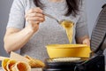 A woman is using a non stick electrical waffle cone maker to make homemade ice cream cones