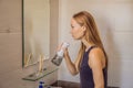 Woman using an oral irrigator in bathroom Royalty Free Stock Photo