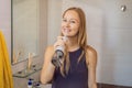 Woman using an oral irrigator in bathroom Royalty Free Stock Photo