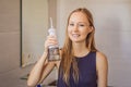 Woman using an oral irrigator in bathroom Royalty Free Stock Photo