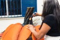 Woman using a paintbrush to paint a giant polystyrene figure of a pumpkin