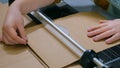 Woman using paper cutter, guillotine, designer working